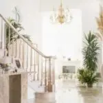 Bright interior with staircase, chandelier, and plants showcasing HVAC climate control by Boutwell&rsquo;s Air Masters.