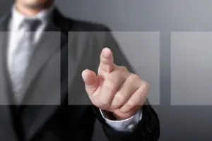 Business professional in a suit pointing towards blank screens, representing guidance on central air conditioning installation for older homes.