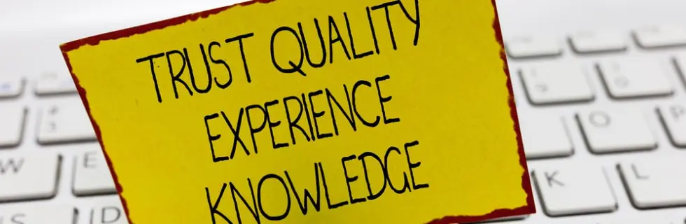 Trust quality experience knowledge sign on a yellow sticky note placed on a keyboard, emphasizing the importance of reliable HVAC services and expertise in maintaining home comfort.
