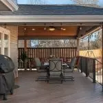 Outdoor patio with covered seating area, grill, and wooden deck, enhancing winter-friendly outdoor living spaces for social gatherings and comfort.