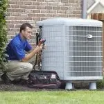 HVAC technician working on an air conditioning unit with diagnostic equipment in a residential area in Austin, Texas.