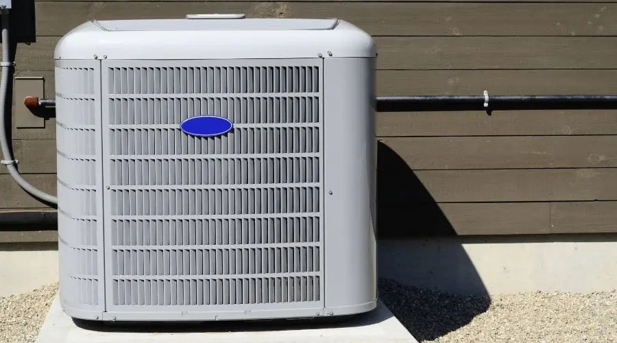 Air conditioning unit installed outside a home, emphasizing HVAC maintenance and efficiency for homeowners.