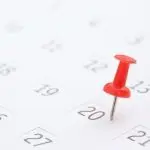 Close-up of a calendar page with a red pushpin on the highlighted date 20th, relevant for A-Plus HVAC services.
