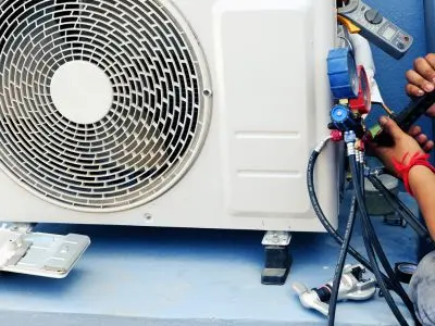 Technician inspecting and servicing a heat pump unit, highlighting maintenance and repair for efficient HVAC performance.