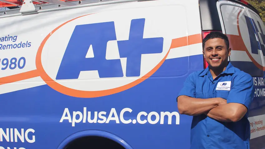 A-Plus Air Conditioning technician standing confidently next to branded service van, showcasing HVAC solutions and energy efficiency expertise.