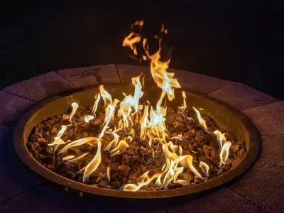Fire pit with vibrant flames and glowing embers, enhancing outdoor winter gatherings and creating a cozy atmosphere.