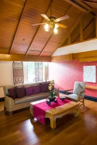 Ceiling fan in a cozy living room with wooden beams, promoting air circulation for cooling comfort during summer.