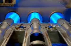Close-up of furnace burners with blue flames, illustrating the heating process for efficient HVAC operation, relevant to winter furnace maintenance and repair services.