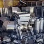 Metal machinery parts and ducts in a workshop for HVAC systems by Atlantic Heating & Air Conditioning.