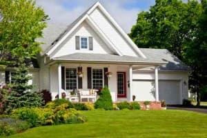 Charming residential home with well-maintained lawn and landscaping, showcasing a welcoming porch, ideal for enjoying outdoor comfort in Boston.