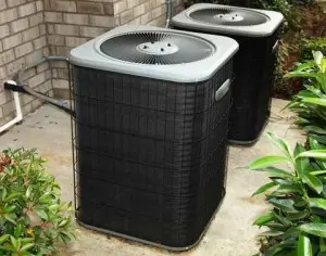 Air conditioning units positioned outdoors among greenery, showcasing energy-efficient HVAC systems relevant to home cooling solutions in Boston.