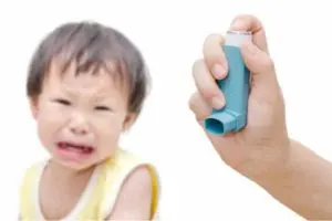 Child with asthma inhaler and distressed expression, highlighting asthma management related to indoor air quality and allergens.