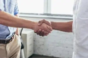 Hands shaking in a professional setting, symbolizing collaboration and partnership in the HVAC industry, relevant to Atlantic Heating & Air Conditioning's acknowledgment of HVAC technicians.