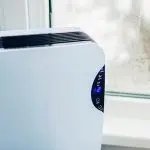 Air purifier with digital display in an indoor setting, enhancing air quality for Atlantic Heating & Air Conditioning.