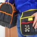 Individual with two tool bags, one orange and one yellow, showcasing tools for emergency plumbing services.