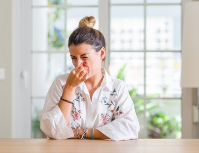 Woman pinching nose in disgust