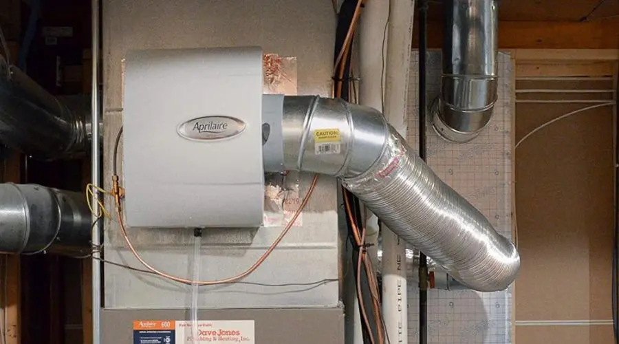 Aprilaire humidifier with ductwork in a utility room, showcasing HVAC efficiency by North Point Air Conditioning & Heating.