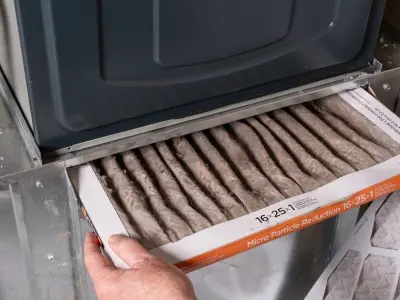 Furnace filter being replaced in HVAC system, emphasizing importance of regular maintenance to prevent overheating and ensure proper airflow.