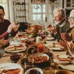 Diverse group enjoying a meal with food and wine, emphasizing community and togetherness for HVAC maintenance awareness.
