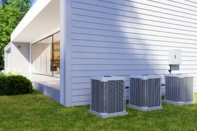Heat pump units installed outside a modern home, showcasing HVAC system components essential for efficient heating and cooling.