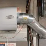Metallic ducting of a ventilation system with labels and wiring from North Point Air Conditioning.