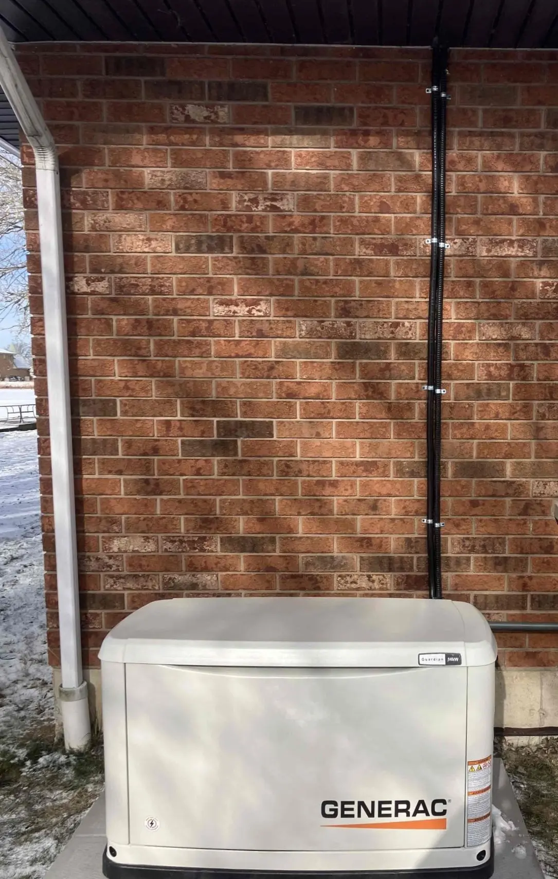 Generac generator installed in Chatham-Kent by Postma with a clean line of electrical wire and a gas line.