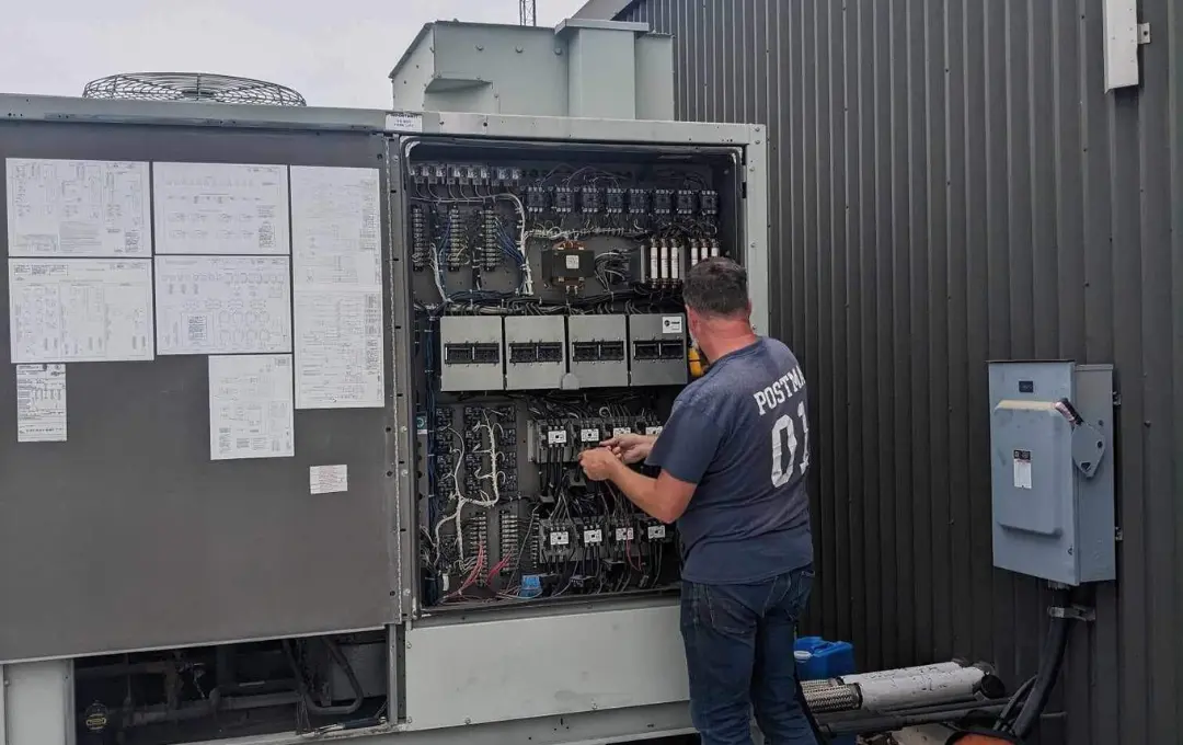 Postma commercial HVAC technician servicing a rooftop unit on a commercial building in Chatham-Kent, Ontario