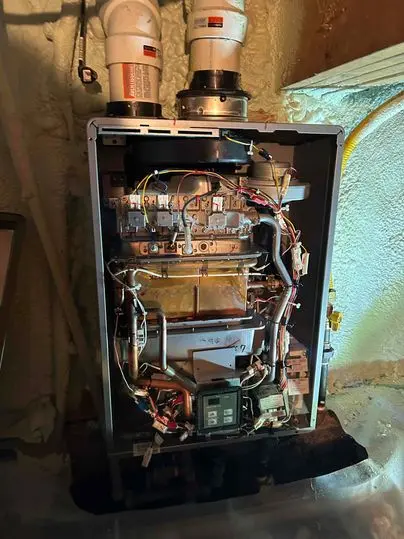 Open furnace during a fall furnace inspection in Chatham-Kent, showing internal components being checked by a technician.
