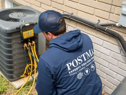 Technician checking home air conditioner refrigerant levels with gauges during AC service in Chatham, Ontario