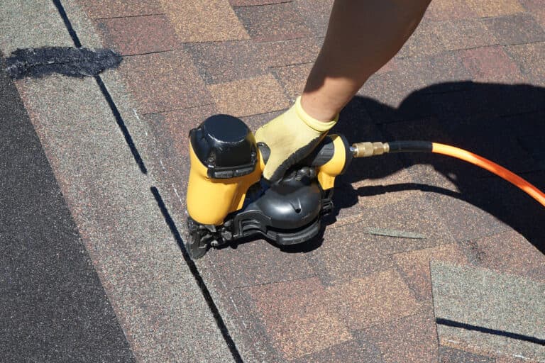 Residential Roofing in Redondo Beach, CA worker using nailgun to paste brown shingles