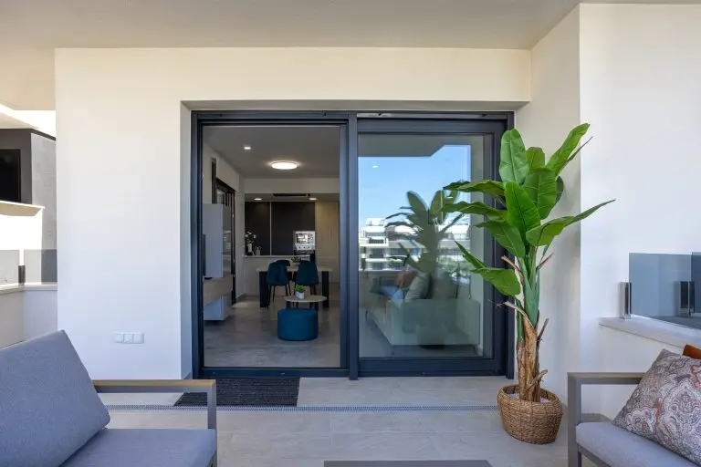 sliding glass doors Contemporary balcony with seating, potted greenery, and access to stylish open plan apartment