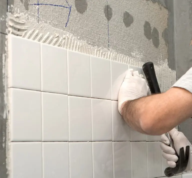 Man setting tile on cement board.