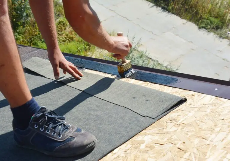 roofing norwalk ca worker applying sealant and pasting shingles