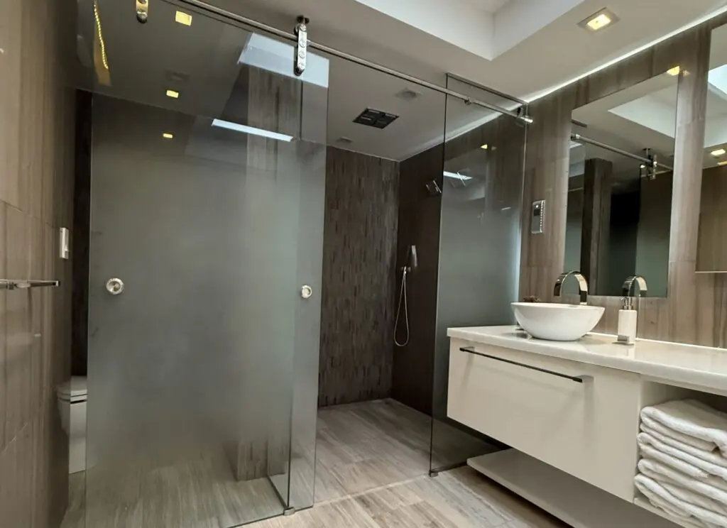 A bright bathroom with a floating vanity and a large shower