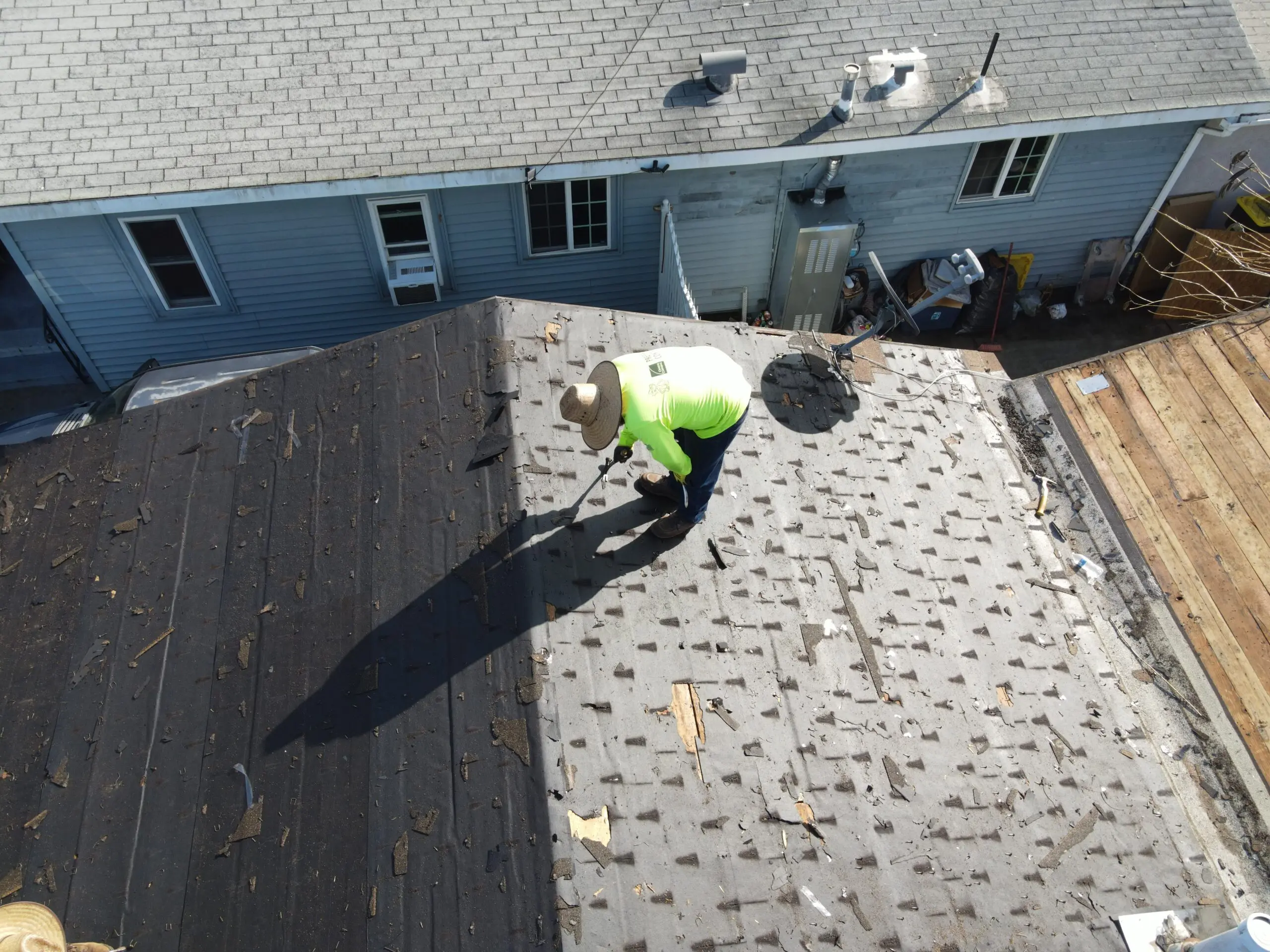 roofing los angeles ca worker removing and replacing shingles