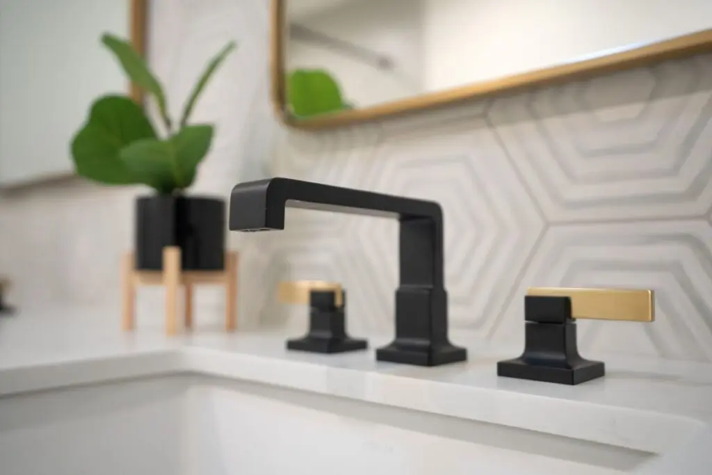 Modern Black and Brass Bathroom Faucet with Geometric Tile Backsplash