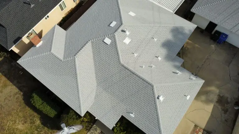 Aerial view of a house with a light grey shingle roof