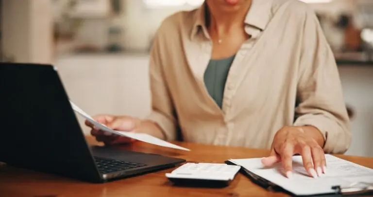 hands and document in apartment with laptop, calculator