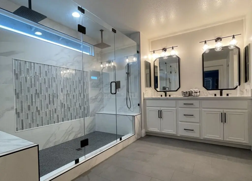 A newly remodeled bathroom with a large shower, two sinks with two large mirrors above
