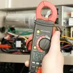 Person's hand using an electrical multimeter at Air Works Heating & Air.