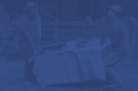 Two technicians lifting a large equipment box outdoors, emphasizing teamwork in HVAC installation and maintenance services.