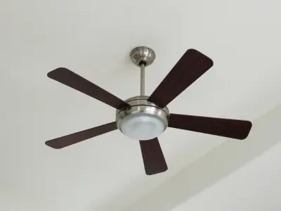 Ceiling fan with five dark wood blades and a light fixture, promoting efficient air circulation for improved indoor comfort and energy savings in conjunction with HVAC systems.
