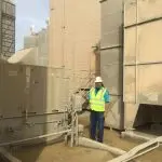 Worker in safety gear near large machinery at The Darville Company’s industrial site, emphasizing safety and professionalism.