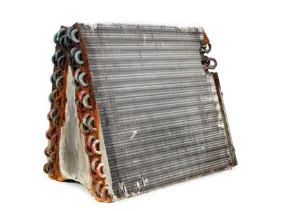 Rusty HVAC evaporator coil with visible corrosion, illustrating potential refrigerant leak issues in older air conditioning systems.