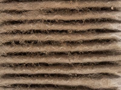 Clogged air filter showing accumulated dust and debris, impacting HVAC airflow and indoor air quality.