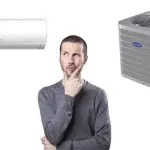 Man considering air conditioning options between a wall-mounted and a larger unit at Chad's AC Direct.