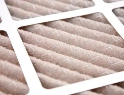 Air filter close-up showing dirty fibers, emphasizing the importance of regular replacement for improved indoor air quality and HVAC efficiency.