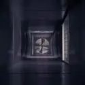 Dimly lit ventilation fan in a tunnel shaft, showcasing industrial air conditioning infrastructure by Chad's AC Direct.