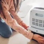 Person in a sweater vacuuming, showcasing home cleanliness related to Chad's AC Direct HVAC services.