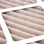 Air filter element for HVAC systems, featuring a textured surface and light pink color within a white frame.